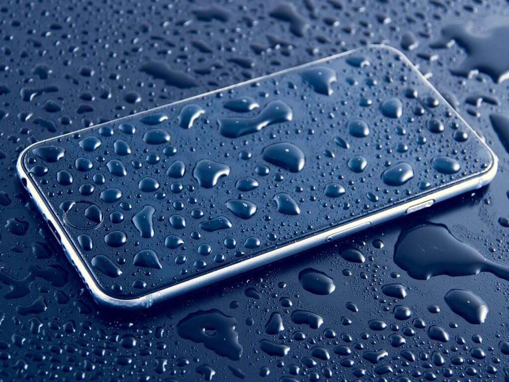 Telefon leżący w deszczu, cały mokry - smartfon do biznesu powinien być odporny na wilgoć.